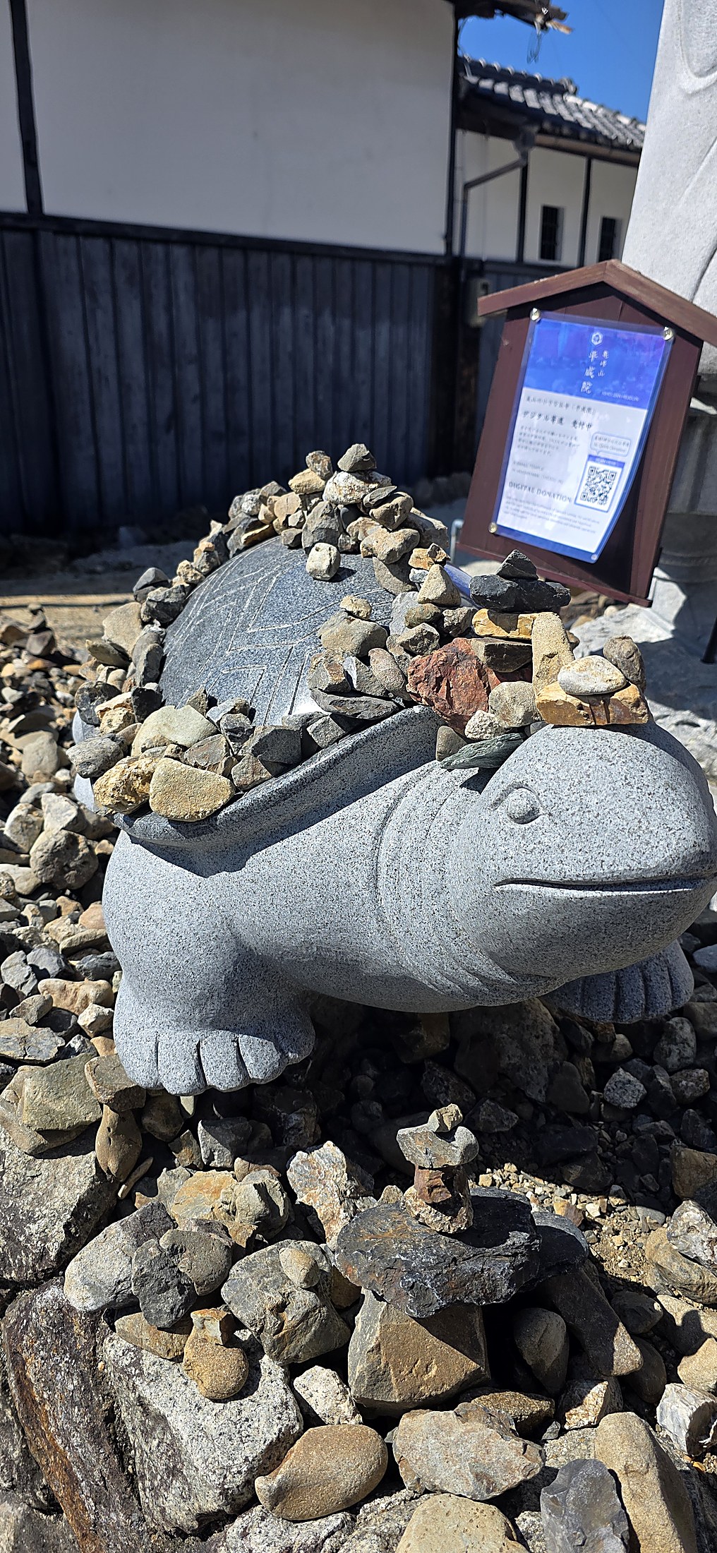 Stein-Schildkrötenfigur mit Steinhaufen in traditioneller japanischer Umgebung