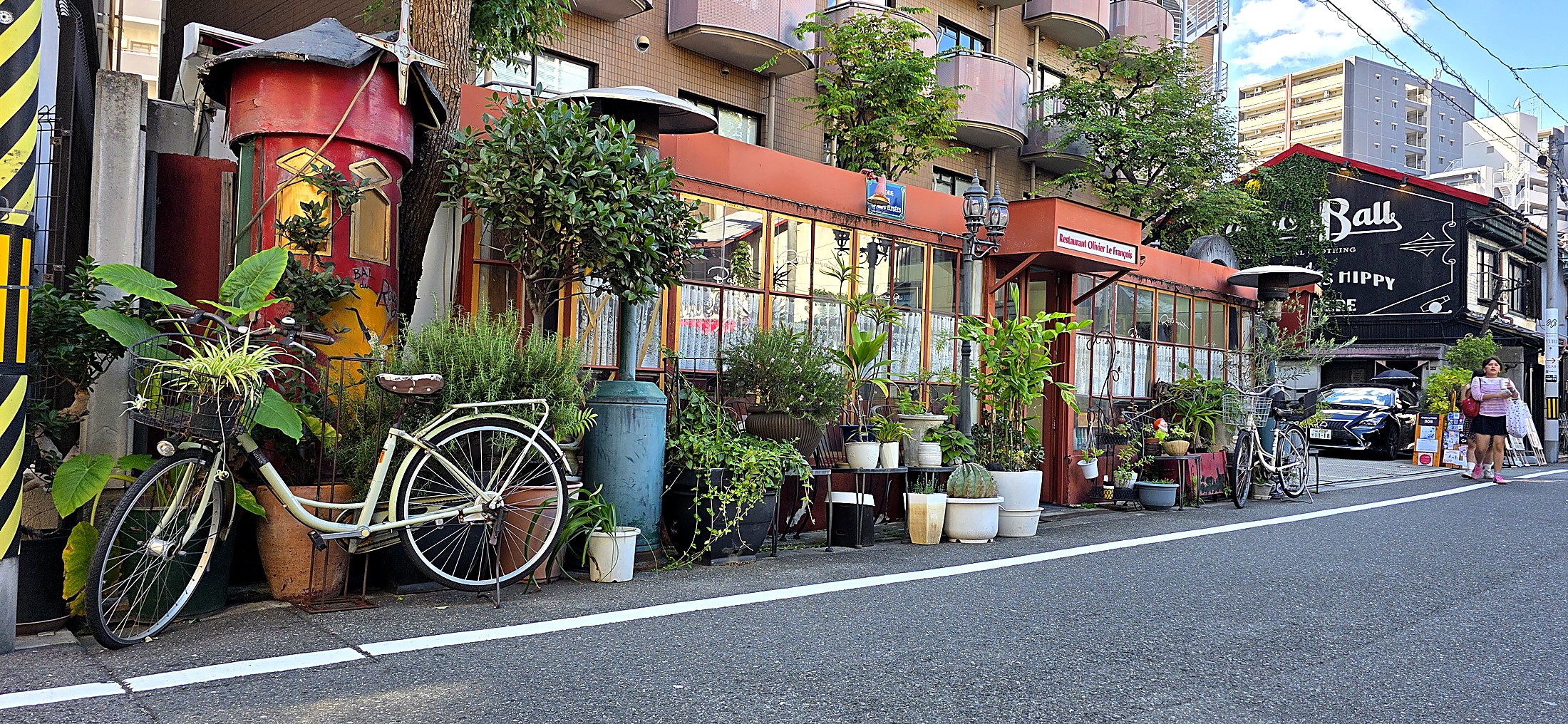Gemütliches Straßencafé mit Pflanzen in einer japanischen Stadt