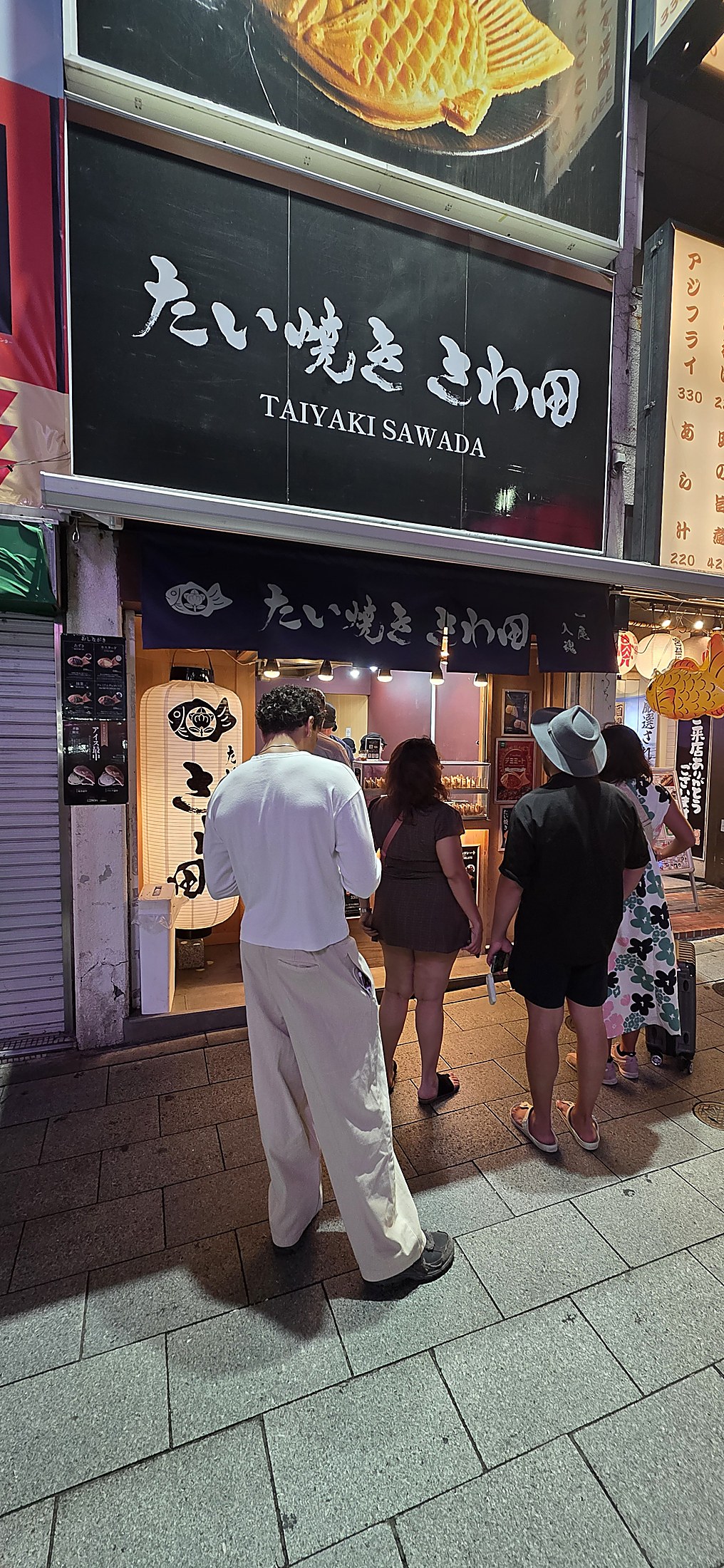Leute warten vor Taiyaki-Laden in Tokios lebendigem Viertel