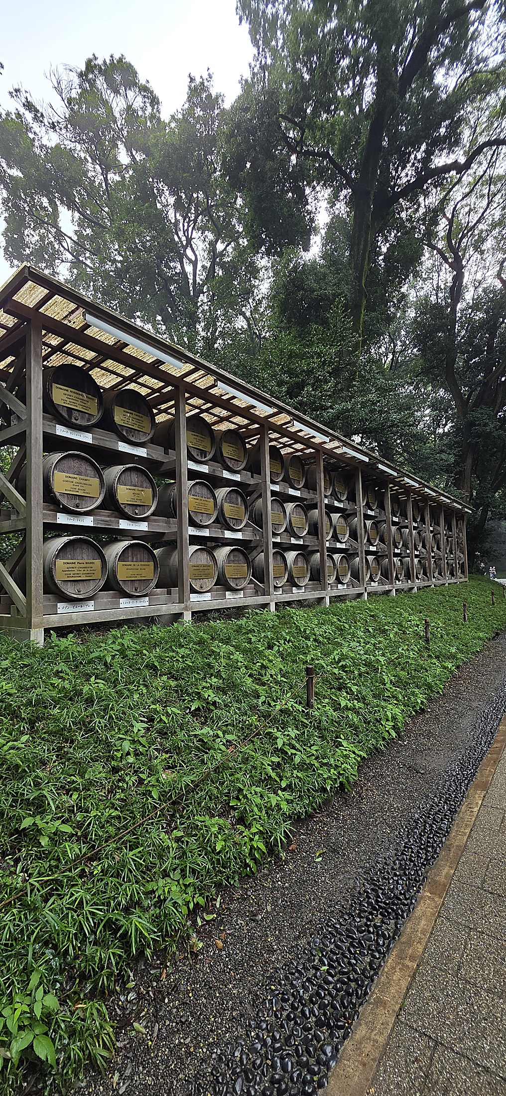 Traditionelle Holzfässer in einem grünen Park in Tokio
