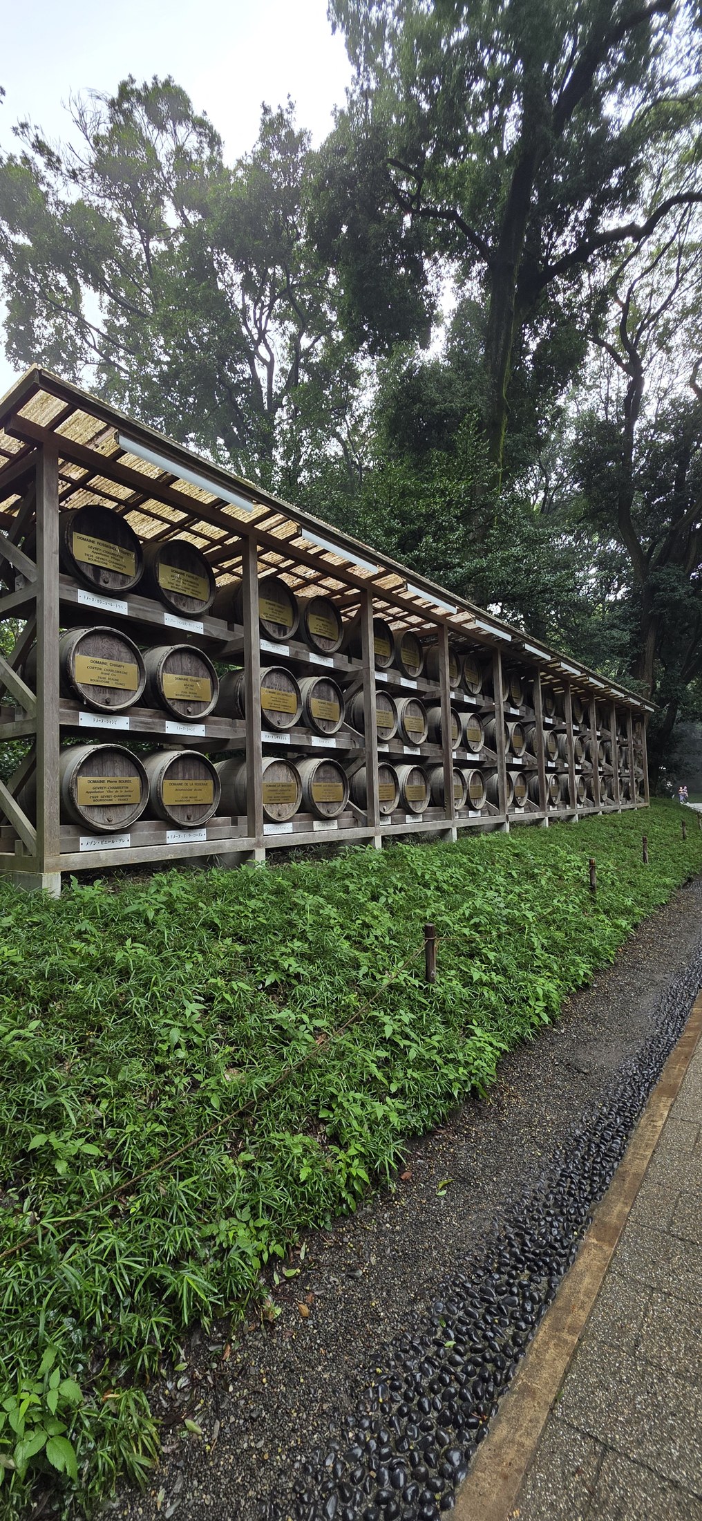 Traditionelle Holzfässer in einem grünen Park in Tokio